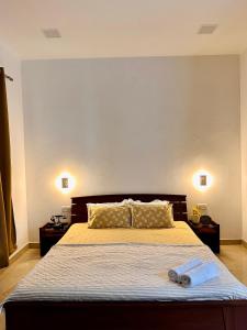 a bedroom with a bed with two towels on it at Teak Stays in Prayagraj