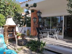 a house with a patio with a table and chairs at 3 bedrooms house at Alcanar 100 m away from the beach with terrace and wifi in Alcanar