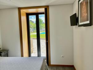 a bedroom with a sliding glass door with a view at Casa das Varzielas in Mondim de Basto