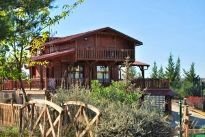a wooden house with a porch and a fence at 5 bedrooms chalet with shared pool jacuzzi and terrace at Alcaniz in Alcañiz
