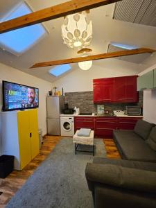 a living room with a couch and a kitchen with red cabinets at AMAZING OPEN PLAN LIVING in Manchester