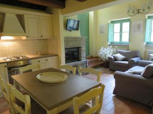 a kitchen and living room with a table and a couch at La Luna Nel Pozzo in Castiglion Fibocchi