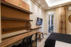 a living room with a table and a tv at GPX CLR GuestSuite No1 in Larisa
