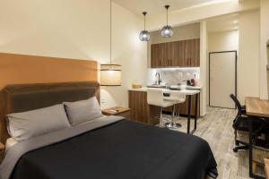 a hotel room with a bed and a kitchen at GPX CLR - Guest Apartment No1 in Larisa