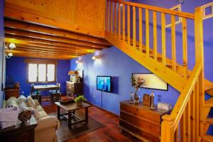 sala de estar con escalera de madera y paredes azules en 2 bedrooms property with wifi at Avila, en Ávila