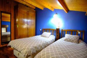 1 dormitorio con 2 camas y pared azul en 2 bedrooms property with wifi at Avila, en Ávila