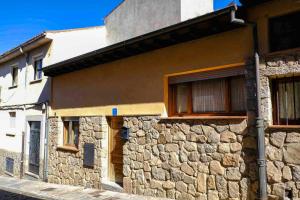 un edificio de piedra con 2 ventanas y una pared de piedra en 2 bedrooms property with wifi at Avila, en Ávila