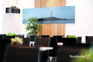 a projection screen in a room with tables and chairs at Vertikalen in Lillesand
