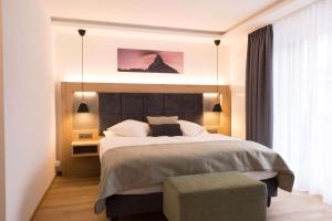 um quarto com uma cama grande e uma janela grande em Hotel Bristol em Zermatt
