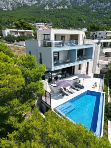 an aerial view of a house with a swimming pool at Luxury Villa Bašak with Infinity Pool and Sea View in Makarska