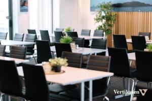 a row of tables and chairs with potted plants on them at Vertikalen in Lillesand