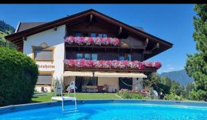 a house with a swimming pool in front of it at Ferienwohnung Birkenheim in Fügenberg