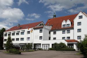 duży biały budynek z czerwonym dachem w obiekcie Lobinger Hotel Weisses Ross w mieście Langenau
