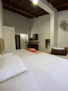 a large bedroom with two white beds and a kitchen at 7 Express in Medellín