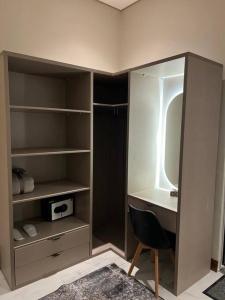 a bathroom with a vanity and a mirror and a chair at Elite Apartment 3 in Riyadh