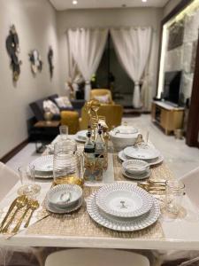 a table with plates and silverware on top of it at Elite Apartment 3 in Riyadh