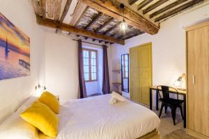 a bedroom with a bed and a desk in a room at Charmant Appartement - Saint Paul de Vence Village in Saint Paul de Vence