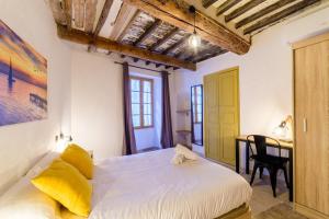 Un dormitorio con una cama y un escritorio en una habitación. en Charmant Appartement - Saint Paul de Vence Village, en Saint-Paul-de-Vence