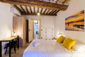 Un dormitorio con una gran cama blanca y un escritorio. en Charmant Appartement - Saint Paul de Vence Village, en Saint-Paul-de-Vence