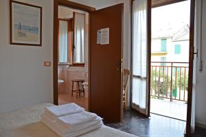 a bedroom with a bed and a door with a balcony at Hotel Corallo in Moneglia