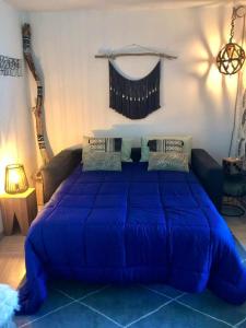 ein großes blaues Bett in einem Zimmer mit Sofa in der Unterkunft Appartement d'une chambre avec piscine partagee terrasse et wifi a Mandelieu la Napoule a 1 km de la plage in Mandelieu-la-Napoule