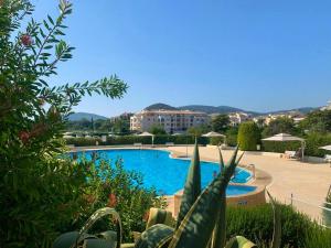 Blick auf einen Pool in einem Resort in der Unterkunft Appartement d'une chambre avec piscine partagee terrasse et wifi a Mandelieu la Napoule a 1 km de la plage in Mandelieu-la-Napoule