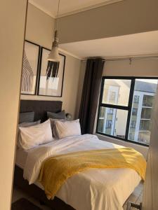a bedroom with a large bed and a window at The Lagoon Exquisite Apartments in Pretoria