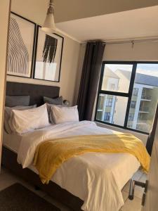 a bedroom with a large bed with a window at The Lagoon Exquisite Apartments in Pretoria