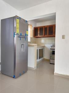 a kitchen with a stainless steel refrigerator in a room at Bright Charming Apartment in San Pedro de Macorís