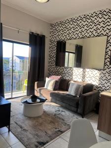 a living room with a couch and a table at The Lagoon Exquisite Apartments in Pretoria