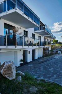 a white building with a balcony and a rock at Welcoming house in Bodman-Ludwigshafen with charming garden in Bodman-Ludwigshafen