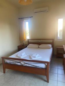 a bedroom with a bed in a room with two windows at Kioni Villas in Frangokastello