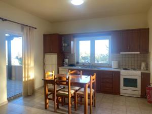 a kitchen with a table and chairs and a dining room at Kioni Villas in Frangokastello