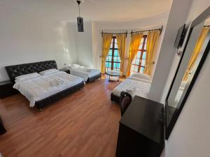 Cette grande chambre comprend deux lits et une table. dans l'établissement Monte Cristo Hotel with rooftop pool, à Saranda