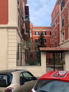 un coche rojo estacionado frente a algunos edificios en Guest House VATICAN MUSEUMS PARVA DOMUS en Roma