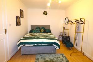 una camera con un letto con una coperta verde e bianca di Large Comfy Studio Flat, Next to Dartford Town Centre, Separate Kitchen, Wifi a Dartford