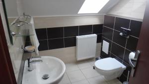 a bathroom with a white toilet and a sink at Penzión Melódia in Kanianka