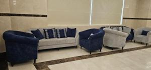 EWG Al Mashaer Hotel في مكة المكرمة: غرفة معيشة مع أريكة وكرسيين