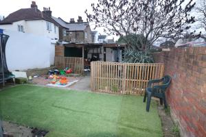 a small backyard with a fence and a lawn at Large Comfy Studio Flat, Next to Dartford Town Centre, Separate Kitchen, Wifi in Dartford