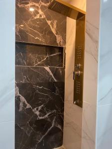 a bathroom with a shower with black marble at Style of Industry in Morbier