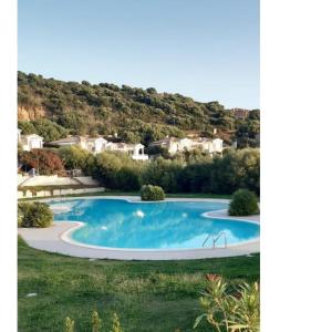 Terra Mala的住宿－Camera con uso piscina vista mare，一座带房子的庭院内的大型蓝色游泳池