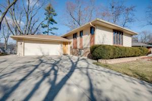 a house with a long shadow on the driveway at Charming Illinois Retreat with Hot Tub, Deck and Grill in Schaumburg
