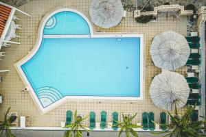 a swimming pool with umbrellas on a wall at Votsalo Tolo in Tolo