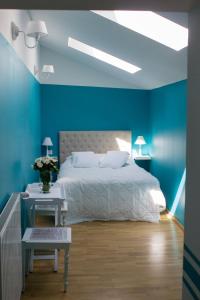- une chambre bleue avec un lit et une table dans l'établissement Le Quatorze bis, à Compiègne