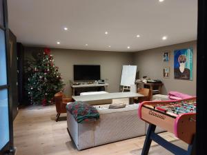 un salon avec un arbre de Noël et une table dans l'établissement Le Quatorze bis, à Compiègne