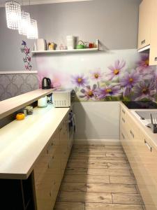 a kitchen with purple flowers on the wall at Selenza Apartament in Wrocław