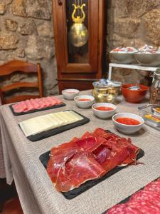 einen Tisch mit Fleisch und anderen Lebensmitteln darauf in der Unterkunft Casa Rural La Fuente del Jerte in Navaconcejo