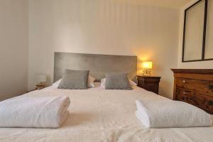 Un dormitorio con una cama blanca con dos almohadas. en Le 828 appartement proche du centre ville, en Vannes