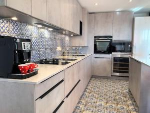uma grande cozinha com armários e electrodomésticos brancos em Le 828 : appartement en plein centre de Vannes em Vannes