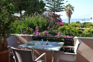 a table and chairs on a patio with flowers at Melina's House in Stalos